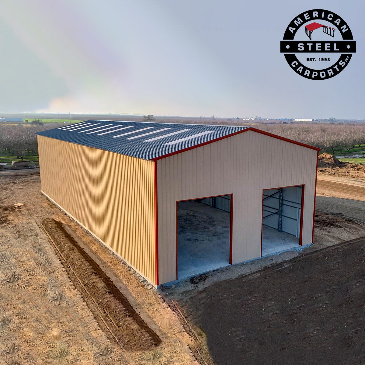 Aerial view of tan steel workshop with dark roof and red trim
