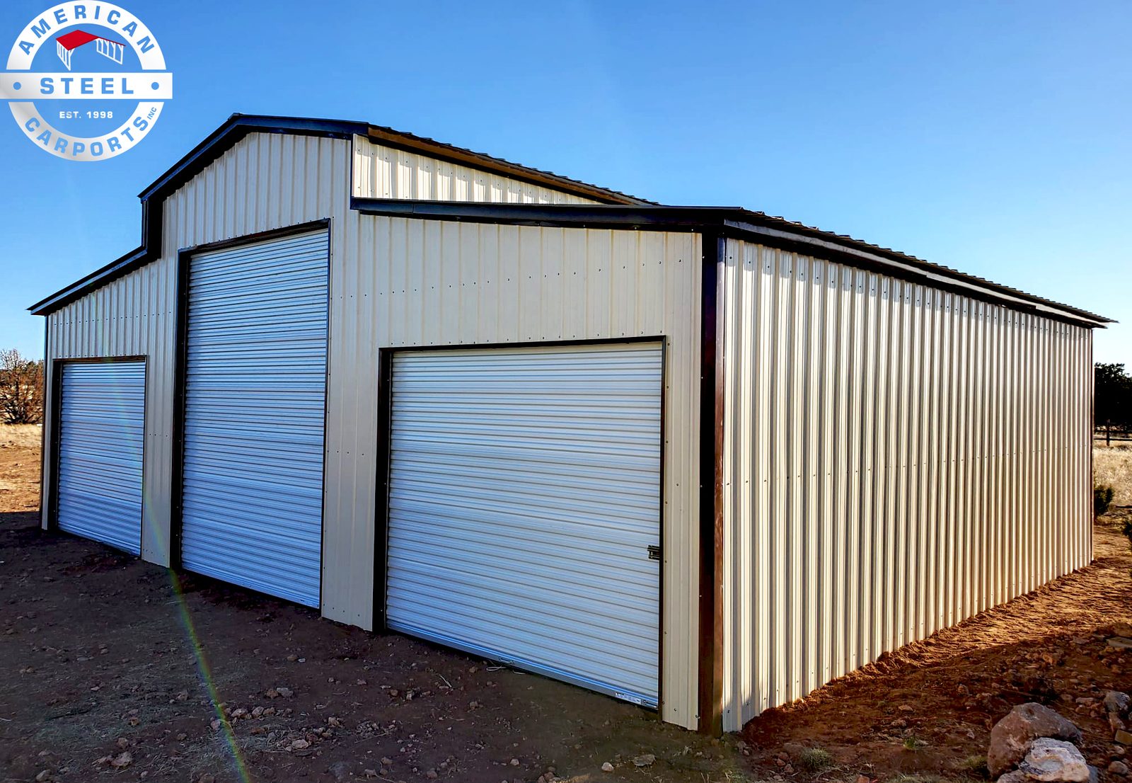 Cream steel barn with dual lean-tos and white roll-up doors