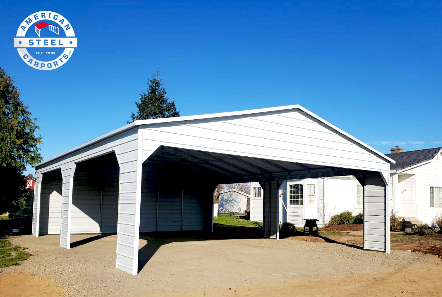 White residential steel carport with scalloped trim beside a home