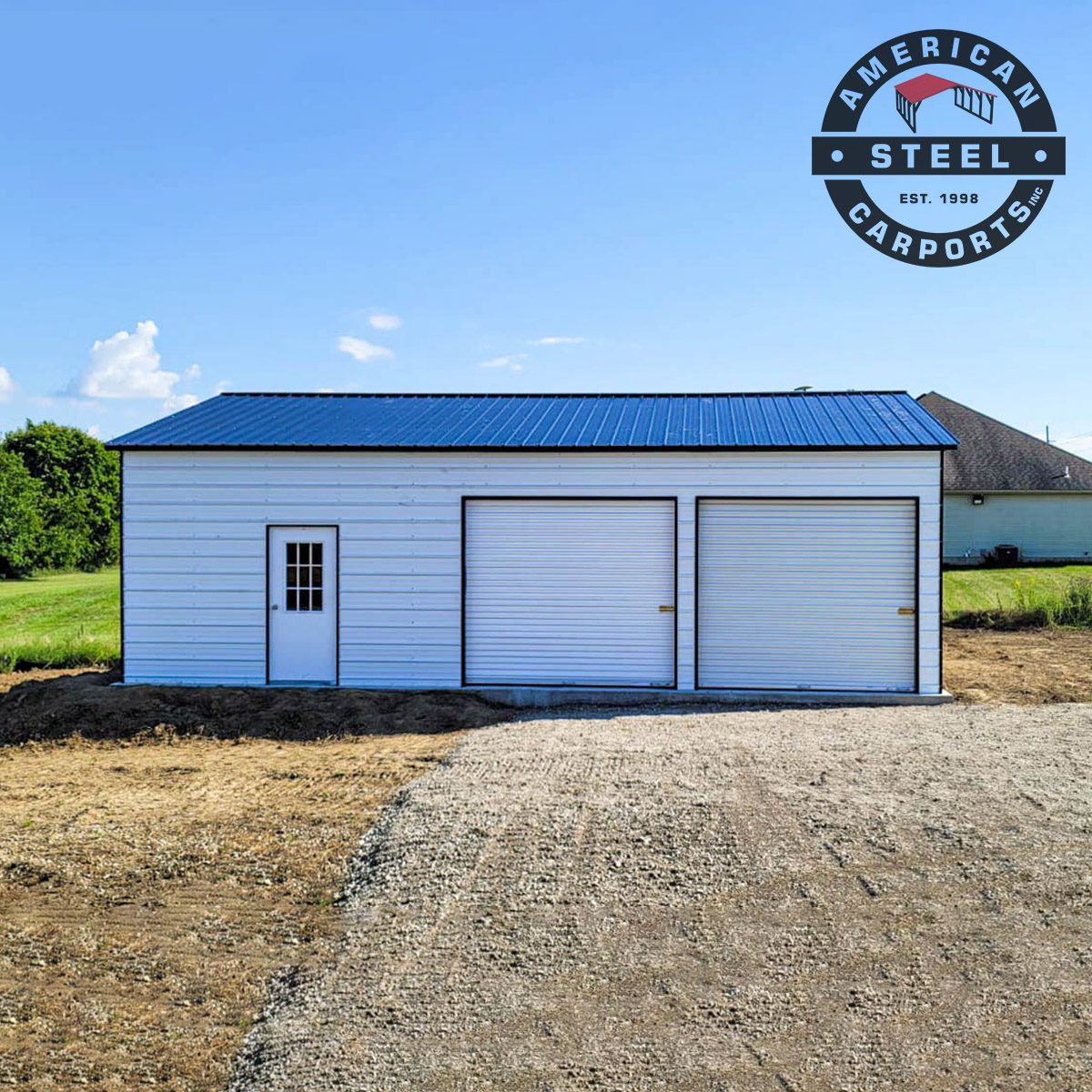 Side view of white steel garage with blue roof and two roll-up doors