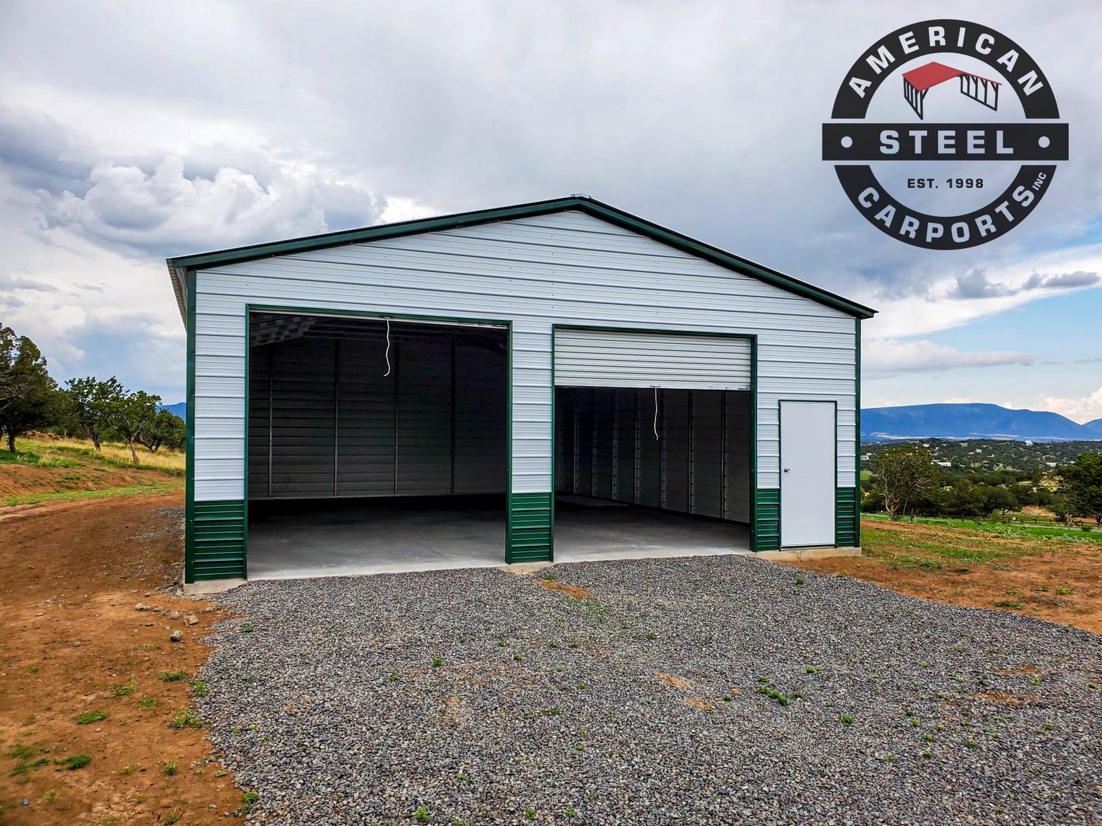 White and green steel garage with vertical roof in mountain setting