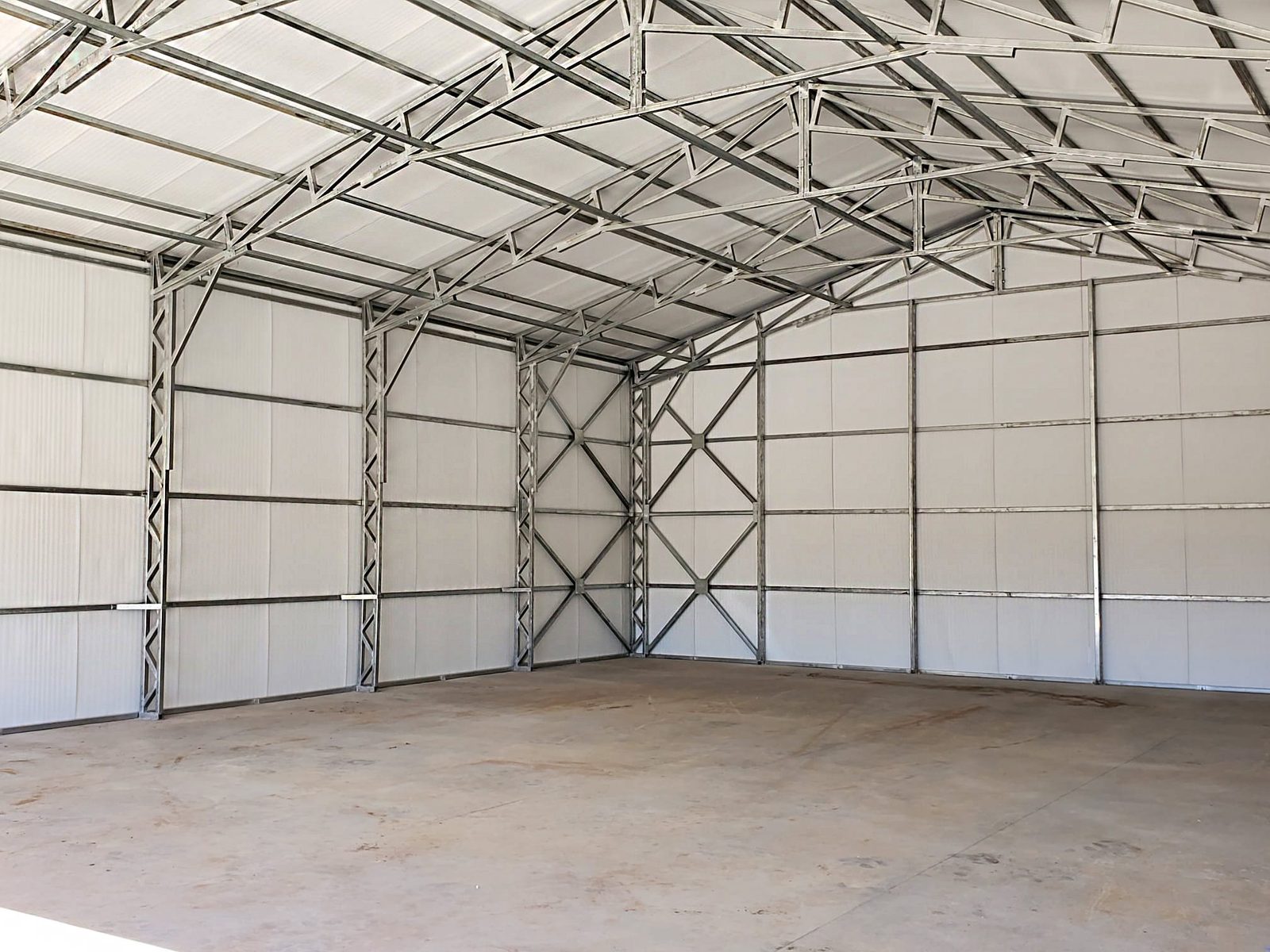 Clear-span steel building interior showing tubular frame and trusses