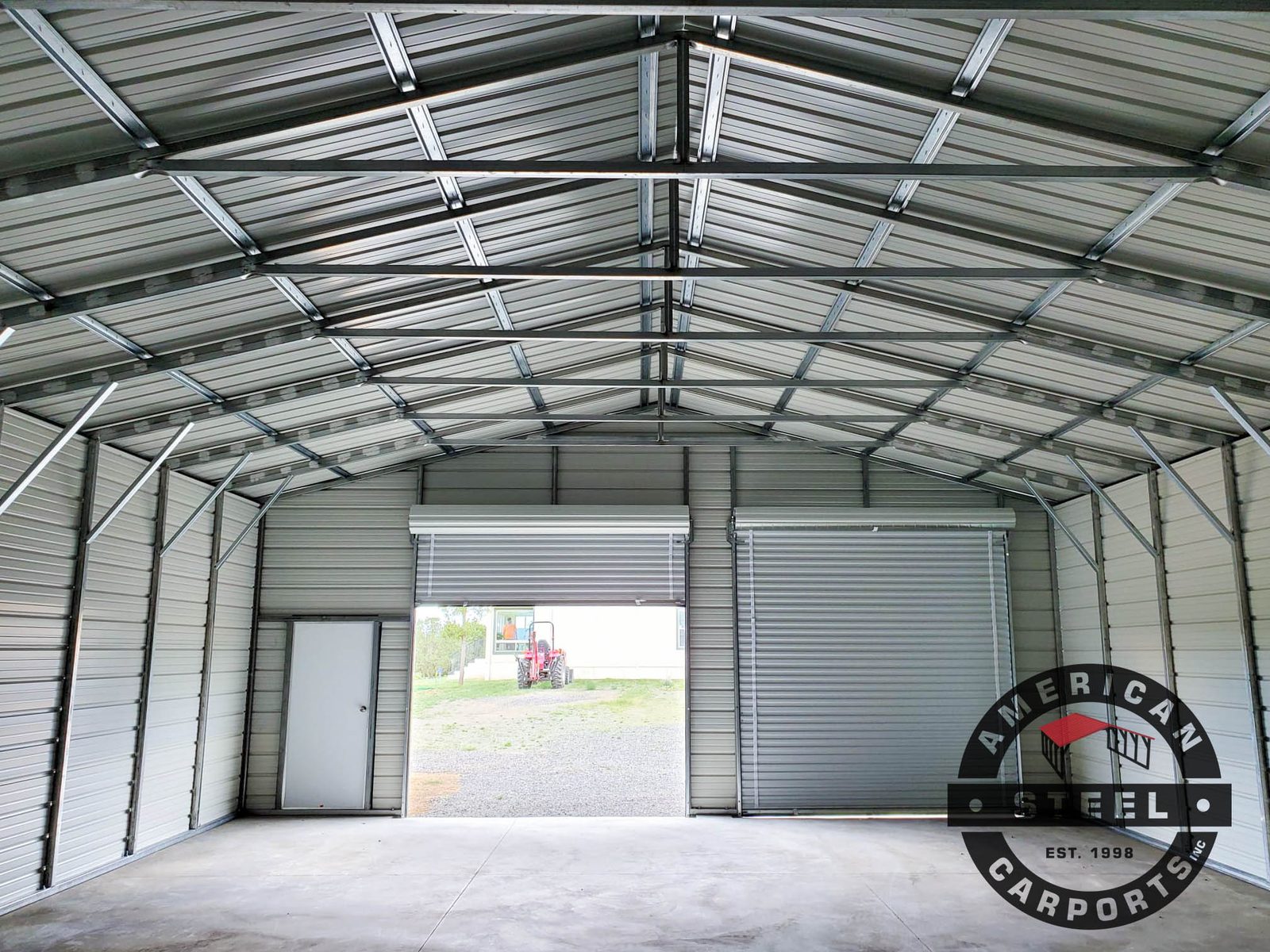 Steel workshop interior with open roll-up bay and galvanized framing