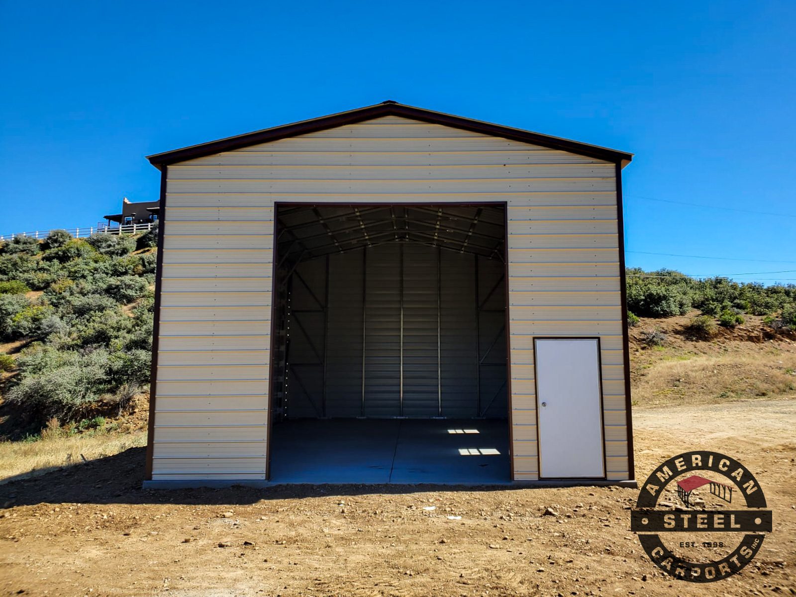 Tall single-bay steel RV garage with roll-up door and walk-in